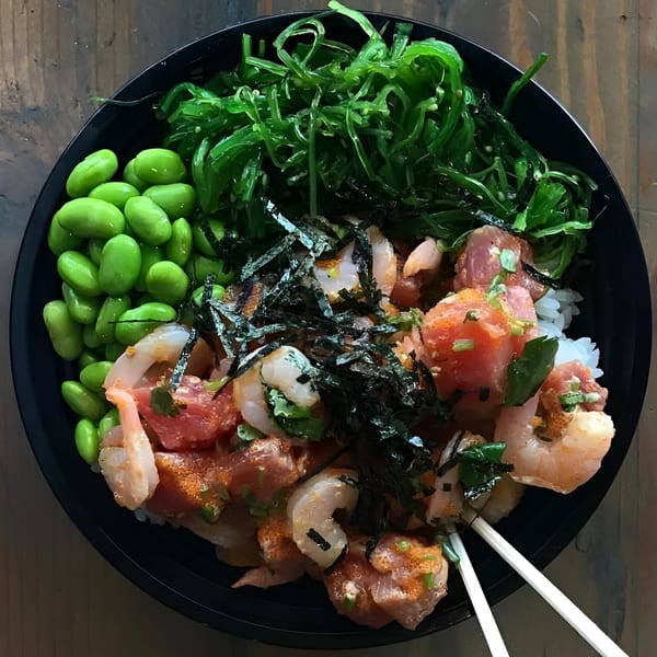 Poke Chop poke bowl with tuna, shrimp, edamame, seaweed salad, and nori on rice.