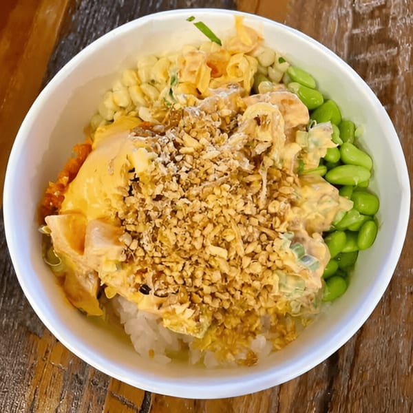A Poke Chop poke bowl with rice, creamy sauce, edamame, corn, and crispy toppings.