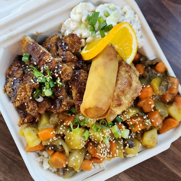 Poke Chop's poke bowl with crispy chicken, egg roll, potato salad, and mixed vegetables.