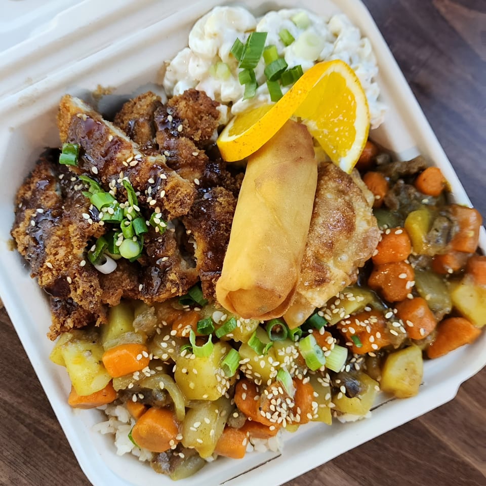 Poke Chop's poke bowl with crispy chicken, egg roll, potato salad, and mixed vegetables.