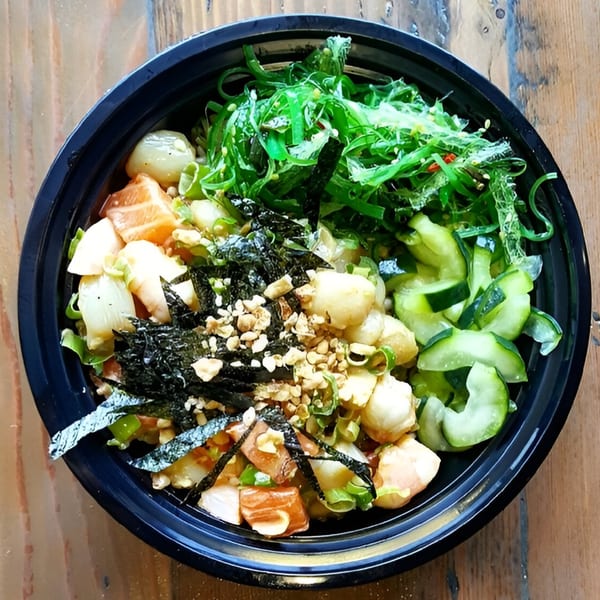 Poke Chop poke bowl with salmon, scallops, seaweed, cucumbers, nori, and nuts.